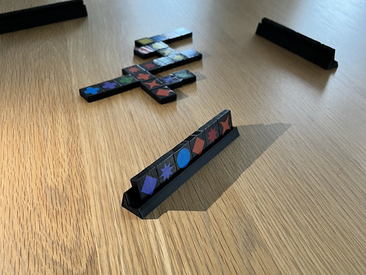 Game tile holder holding six Qwirkle travel edition tiles for reference 